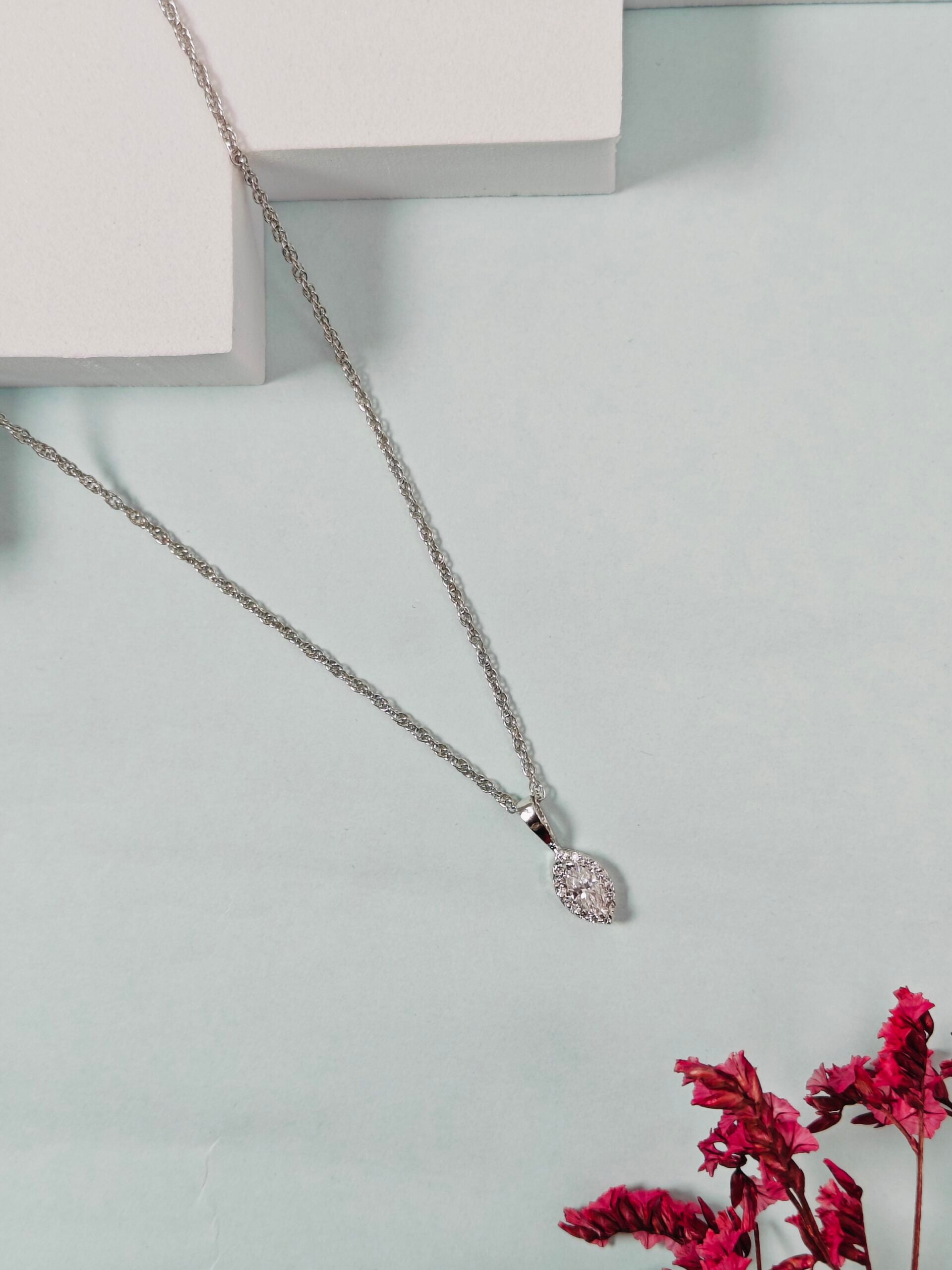 Silver necklace with a pendant on a light gray background